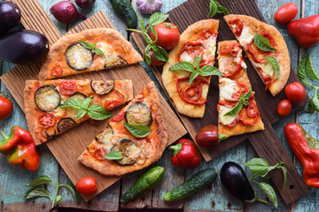 Healthy vegetarian meal. Homemade rustic pizzas with vegetables on oak cutting boards with raw ingredients