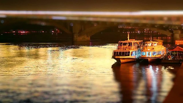 Pleasure boats on the quay at night, tourist pleasure boats at night, Quay at night timelapse, Pleasure boats on the bridge background at night