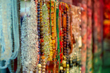 Colorful hanging beads, rosaries, different necklaces. Eastern market