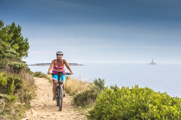 Kroatien, Istrien, Pula, Kap Kamenjak, Mountainbiker auf dem Trail am Meer