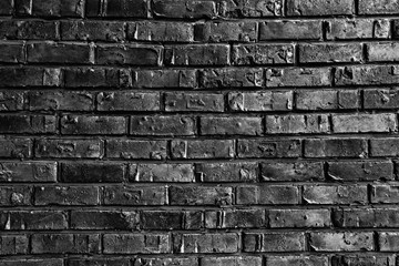 The rough wall is lined with bricks with rough edges on black and white photography