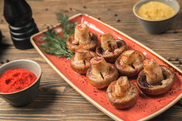 stewed champignons on a red plate with spices