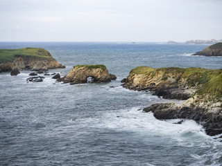 Fototapeta na wymiar Paisaje de costa en Fondo del Prado en Cantabria, con el mar chocando en los peñascos, verano de 2018