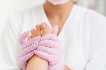 Professional foot massage using moisturizing foam.Final stage of professional pedicure.Skin...