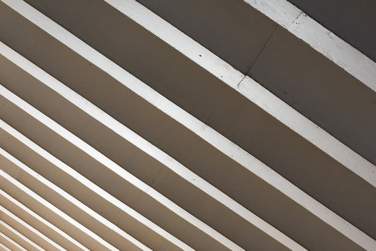 Parallel concrete roof beams letting in light in public space