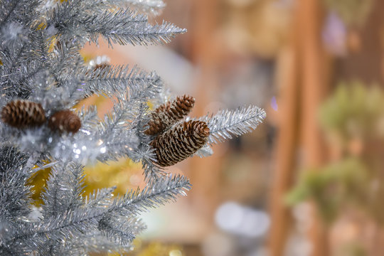 Christmas Tree decoration. Silver artificial tree with cones, new year background