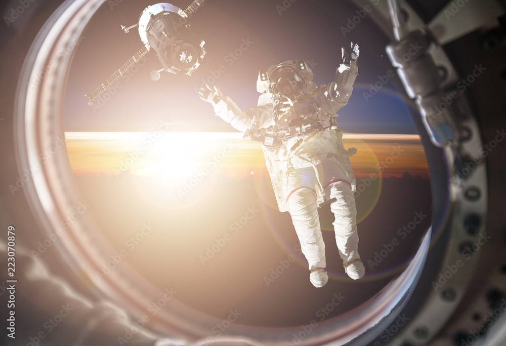 Poster view through the space ship illuminator of astronaut in open spacce with flare frome the star (image