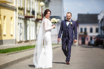 loving couple of newlyweds walks in the old city in summer sunny day