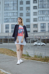 Obraz premium Beautiful woman with nude legs walking around city street wearing long white shirt