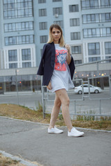 Obraz premium Beautiful woman with nude legs walking around city street wearing long white shirt