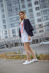 Obraz premium Beautiful woman with nude legs walking around city street wearing long white shirt