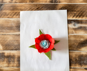 artificial red flowers on a wooden background