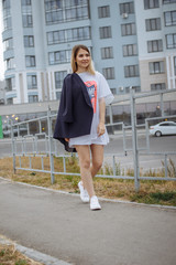 Obraz premium Beautiful woman with nude legs walking around city street wearing long white shirt