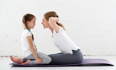 mother with child practicing yoga in lotus pose .