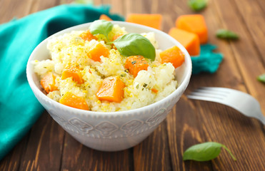 Dish with delicious pumpkin risotto on wooden table