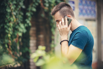 Depressed young man receiving bad, terrible news over his cell phone