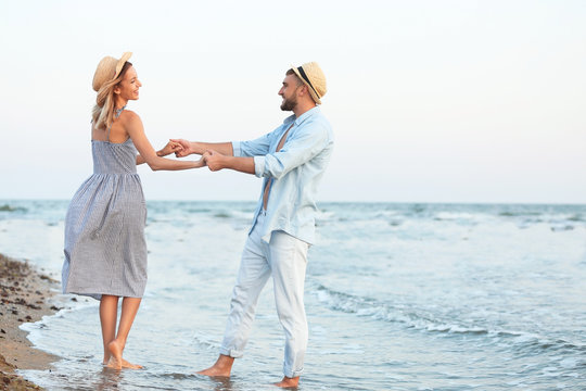 Happy young couple dancing on beautiful beach