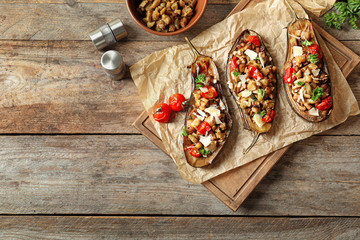 Flat lay composition with stuffed eggplants and space for text on wooden table