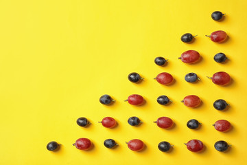 Fresh ripe juicy grapes on yellow background, top view. Space for text