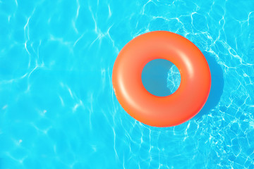Inflatable ring floating in swimming pool on sunny day, top view with space for text