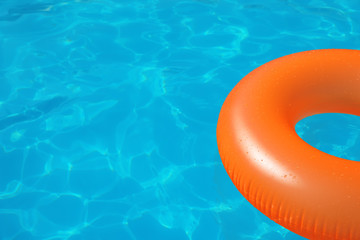 Inflatable ring floating in swimming pool on sunny day. Space for text