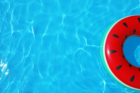 Inflatable ring floating in swimming pool on sunny day, top view with space for text