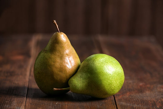 Tasty ripe pears on rustic wooden background