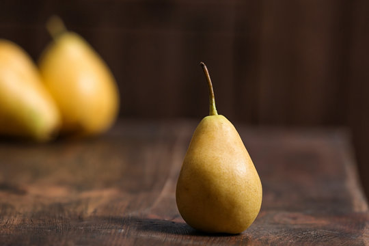 Tasty ripe yellow pear on wooden table
