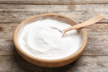 Plate with baking soda on wooden background