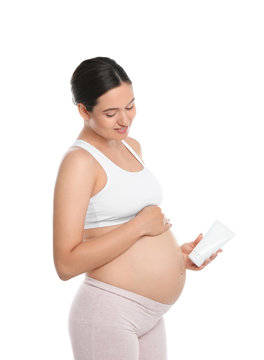 Pregnant woman holding body cream on white background