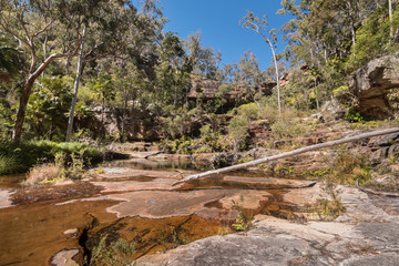 The riverbed below the virtually dry waterfall at the top of Rainbow Waters (Gudda Gumoo) gorge in Blackdown Tableland National Park, Queensland, Australia.