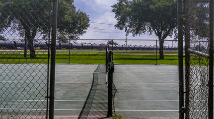Entrance to  two tennis court at a rural high school.