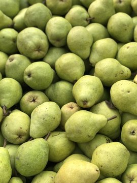 Background of pile of fresh organic green pears at farmers market