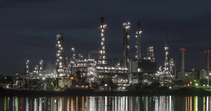 Time Lapse move left oil refinery water reflection at night to day, 5K.
