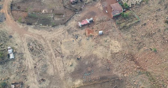 Third world subsistence farm seen from above with makeshift structures for shelter and a few crops