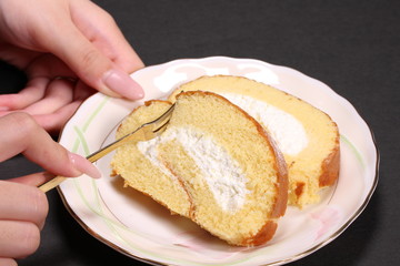ロールケーキを食べる女性の手