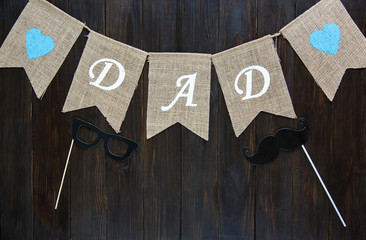 Fathers day composition with flags on brown wooden background. Fathers day concept. Flat lay, copyspace. 