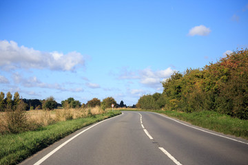Idyllic country road curves through the English countryside on sunny day