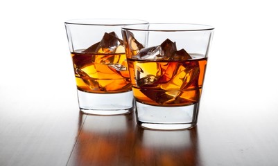 Glasses of Whiskey and Ice on Wooden Table