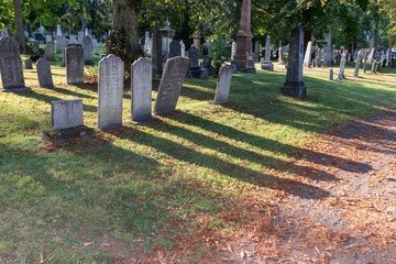 Camp Hill Cemetery Halifax, tombstones with long shadows, late afternoon sun, no people.