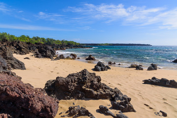 Fototapeta na wymiar lava rocks on sandy ocean beach