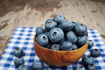 Blueberries in wooden bowls on wood table