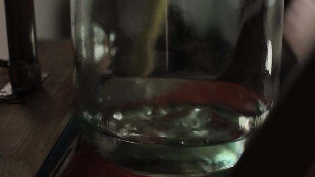 Alcohol distillation equipment, hooch fluid flow into glass jar