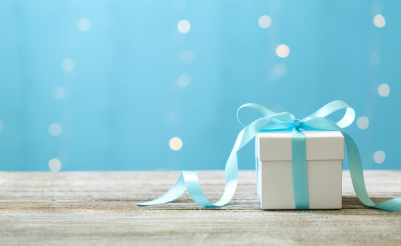 A gift box on a shiny light blue background