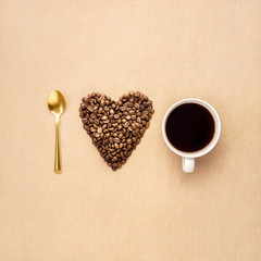 I love coffee / Creative concept photo of heart made of coffee with cup and spoon on brown background.