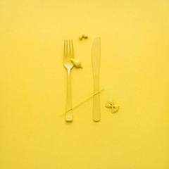 Tasty pasta / Creative still life photo of fork and spoon with raw pasta on yellow background.