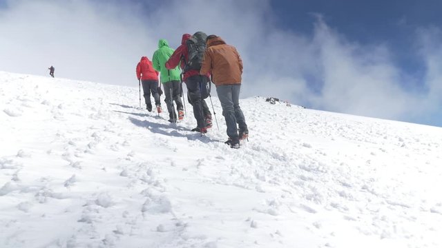 Climbers go up to the top on a snowy slope. On a nice sunny day. Mount Elbrus, Caucasus slow motion