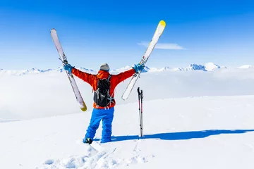 Photo sur Aluminium Sports dhiver Ski in winter season, mountains and ski touring man on the top in sunny day in France, Alps above the clouds.