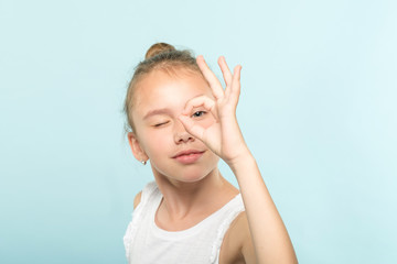 ok gesture. happy facial expression. emotional portrait. funny joyful child looking through...