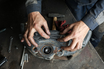The mechanic serves the truck. Repair brake caliper. Close-up. Maintenance. Brake system. Brake spare parts. Hands working close-up.